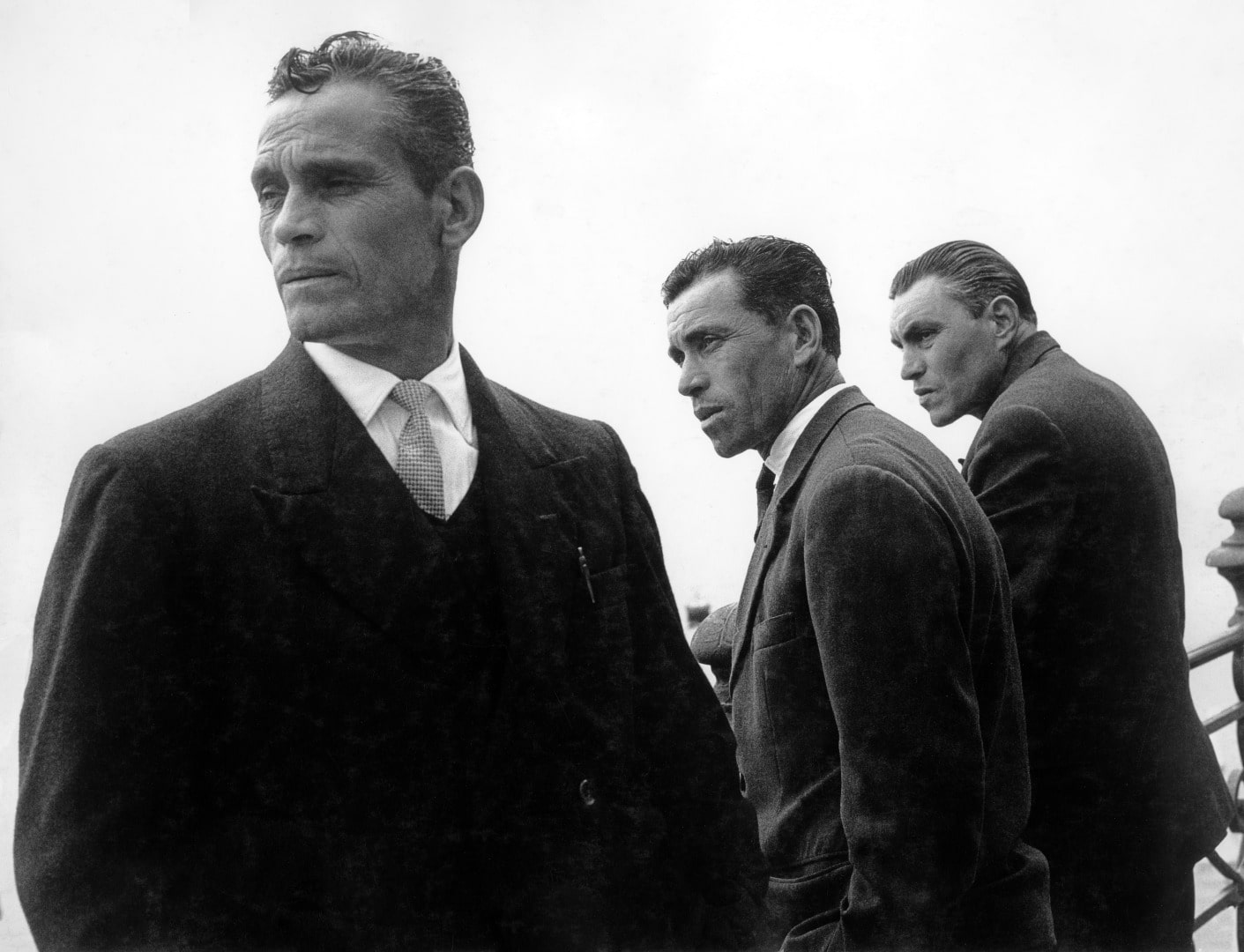 Photographie de trois hommes vêtus de costume trois pièces