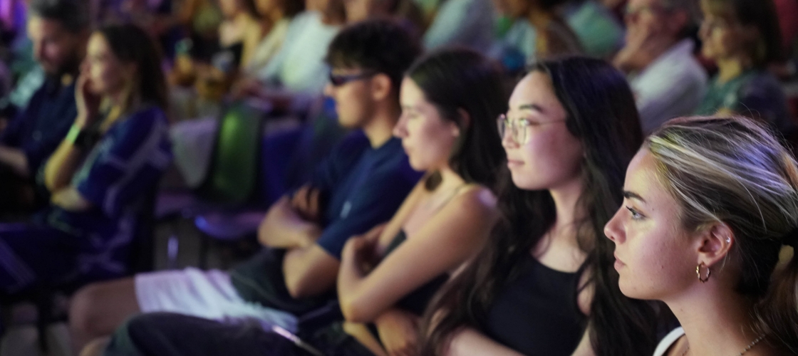 Groupe de personnes assis sur une chaise assistant à une conférence