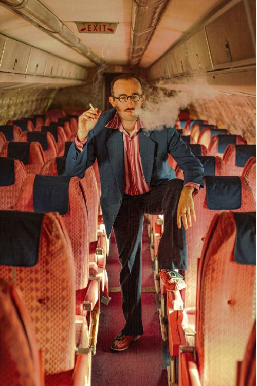 Un homme fume dans un avion